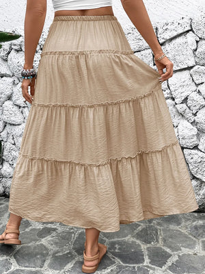 Beige tiered skirt worn by a person standing on a stone path with a stone wall background