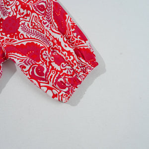 Red and white patterned fabric on a light gray background