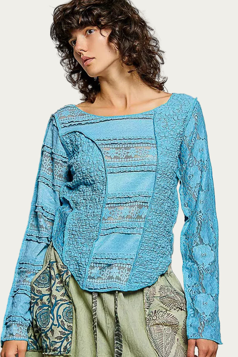 Woman wearing a blue textured top with a neutral background