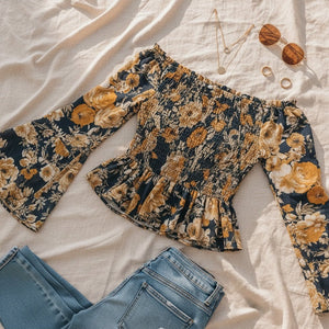 Floral patterned top and jeans on a light fabric background