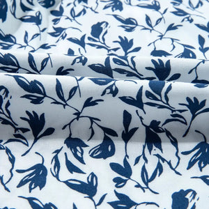 Roll of fabric with blue floral pattern on white background