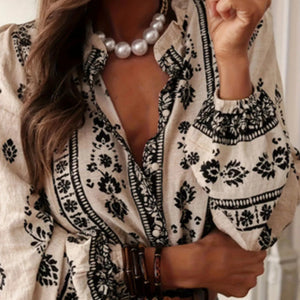 White blouse with black patterns and pearl necklace