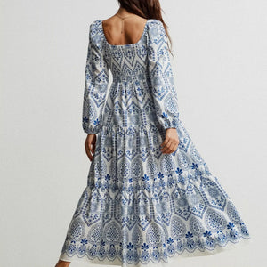 Woman wearing a blue and white patterned dress on a plain background