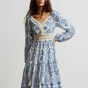 Woman wearing a blue and white patterned dress on a plain background