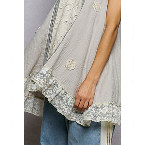 Light gray lace-trimmed garment with floral embellishments on a neutral background