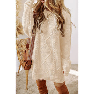 Woman wearing a cream cable knit sweater dress with brown knee-high boots, standing indoors.