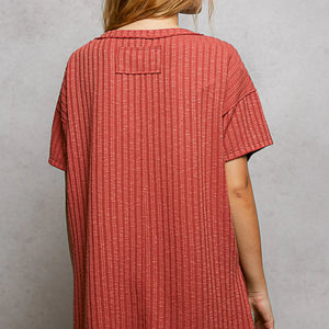 Person wearing a red textured dress against a gray background