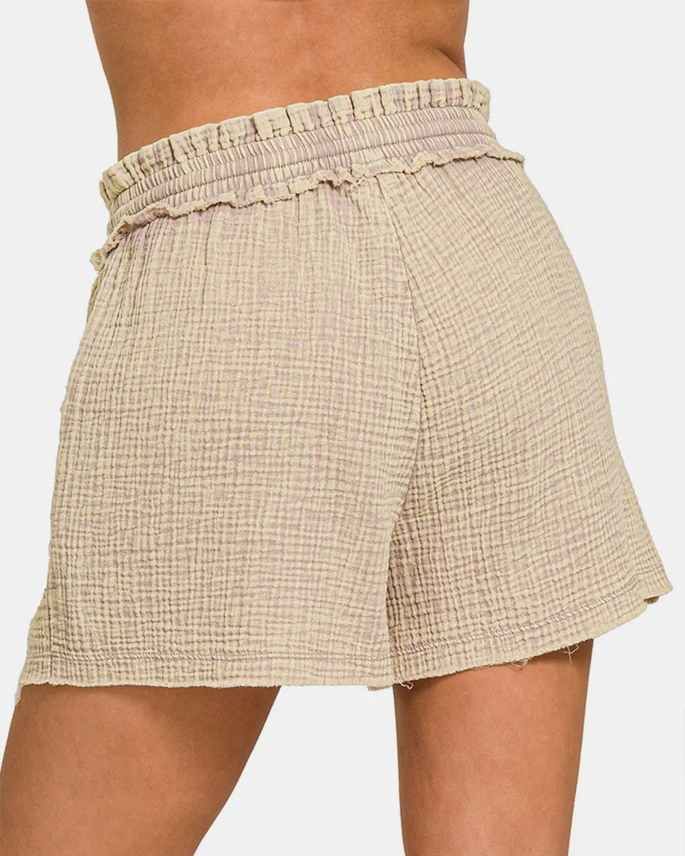 Beige checkered shorts worn by a person on a white background