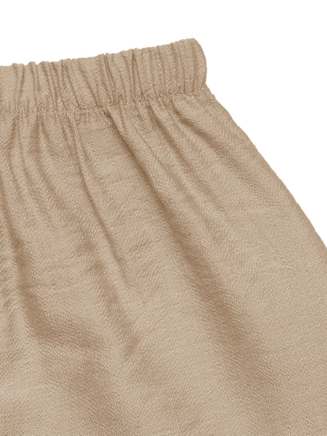 Close-up of beige pants with a white background
