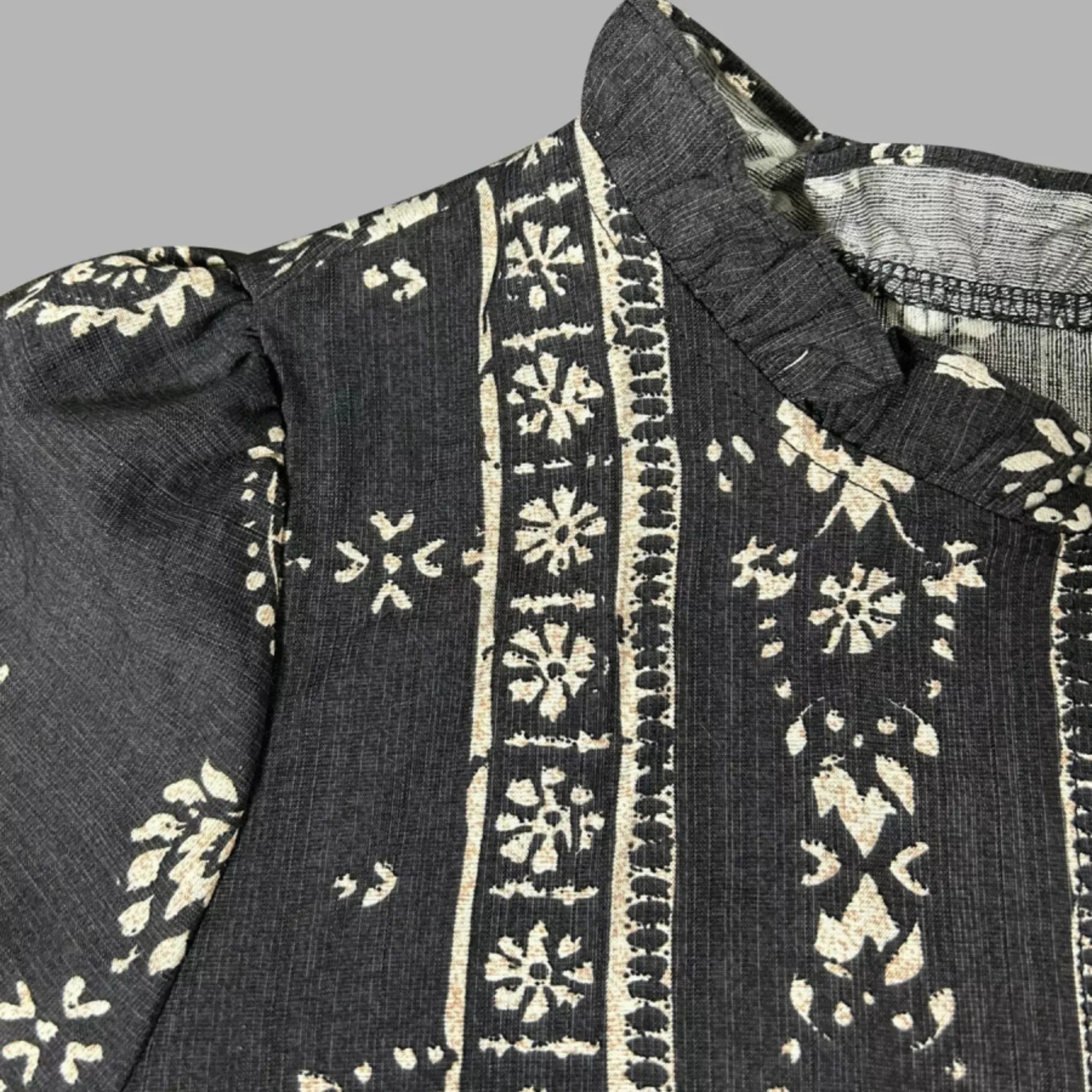 Black fabric with white floral patterns on a gray background