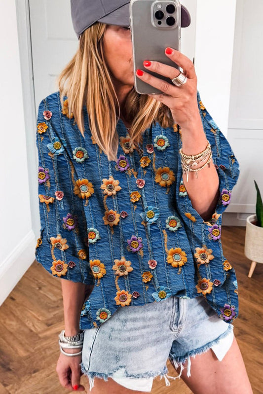 Person wearing a blue floral-patterned kimono with denim shorts indoors.