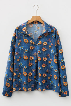 Blue floral-patterned jacket on a wooden hanger against a white background