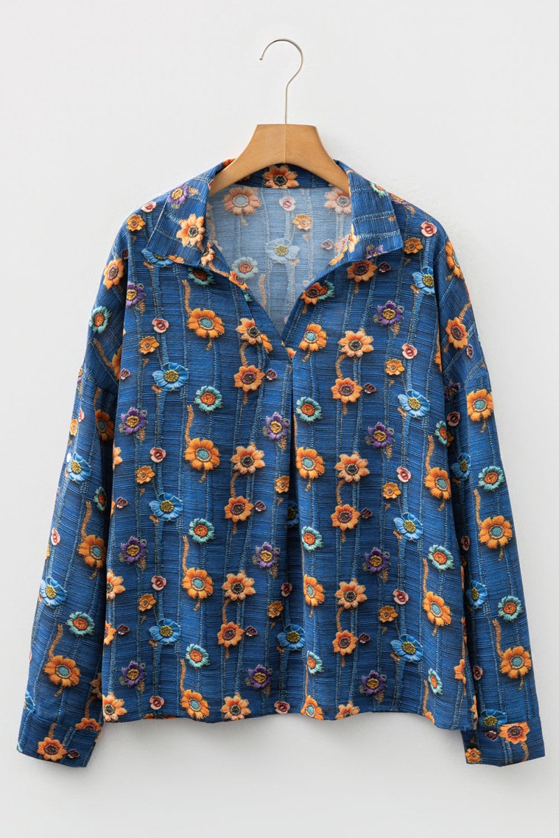 Blue floral-patterned jacket on a wooden hanger against a white background