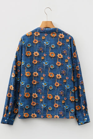 Blue floral patterned shirt on a hanger against a white background