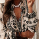 White blouse with black patterns and pearl necklace