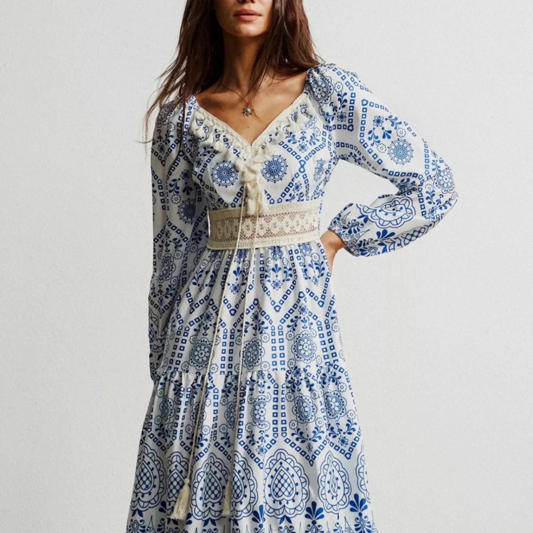 Woman wearing a blue and white patterned dress on a plain background