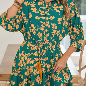 Green dress with orange floral pattern worn by a person indoors.