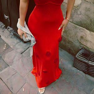 Person wearing a red dress on a stone pavement