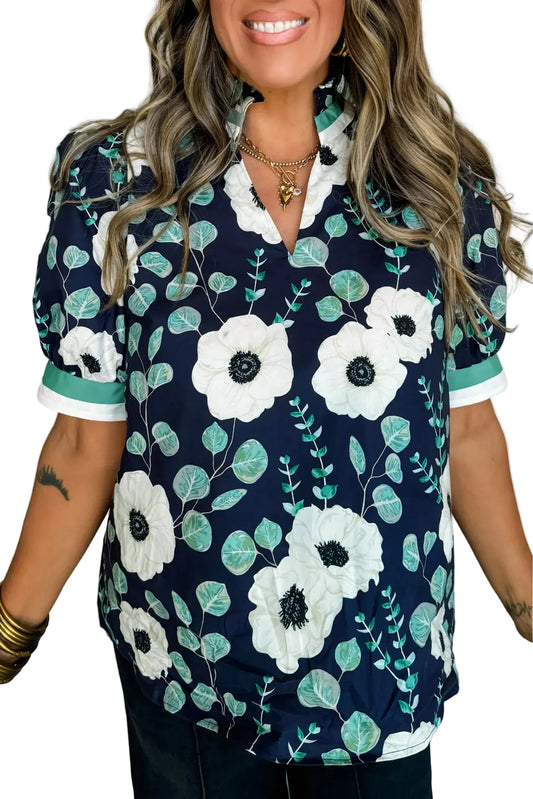 Woman wearing a navy floral blouse with white flowers and green leaves on a white background