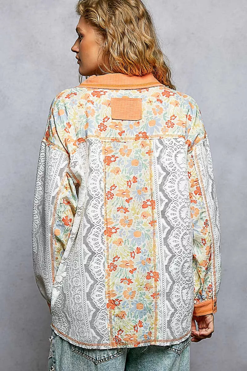 Woman wearing a floral and lace patterned jacket against a gray background