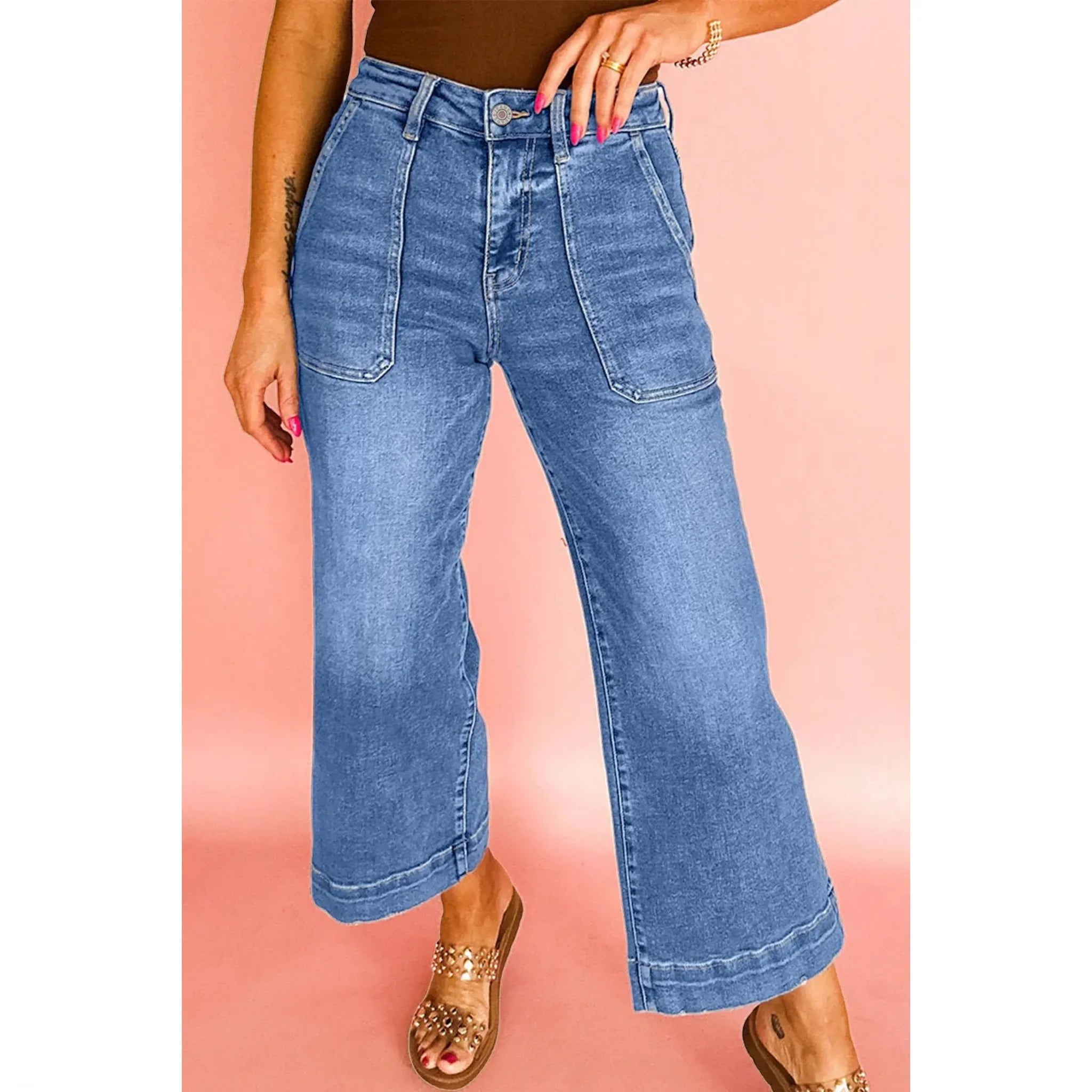 Person wearing blue jeans on a pink background