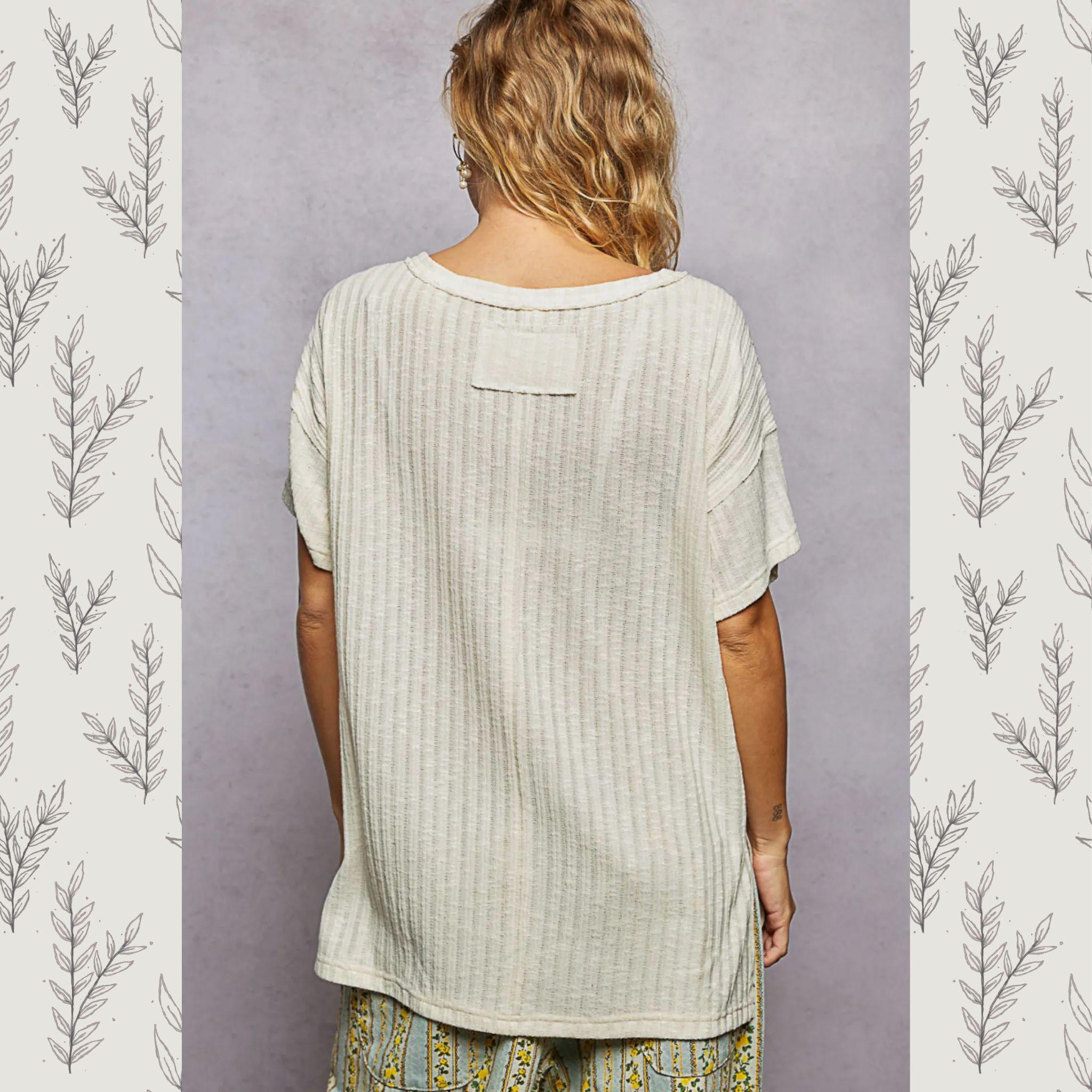 Person wearing a light-colored textured shirt with a neutral background