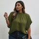 Woman wearing a green blouse against a white wall